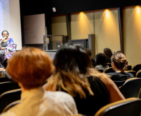 An audience listens to a presentation